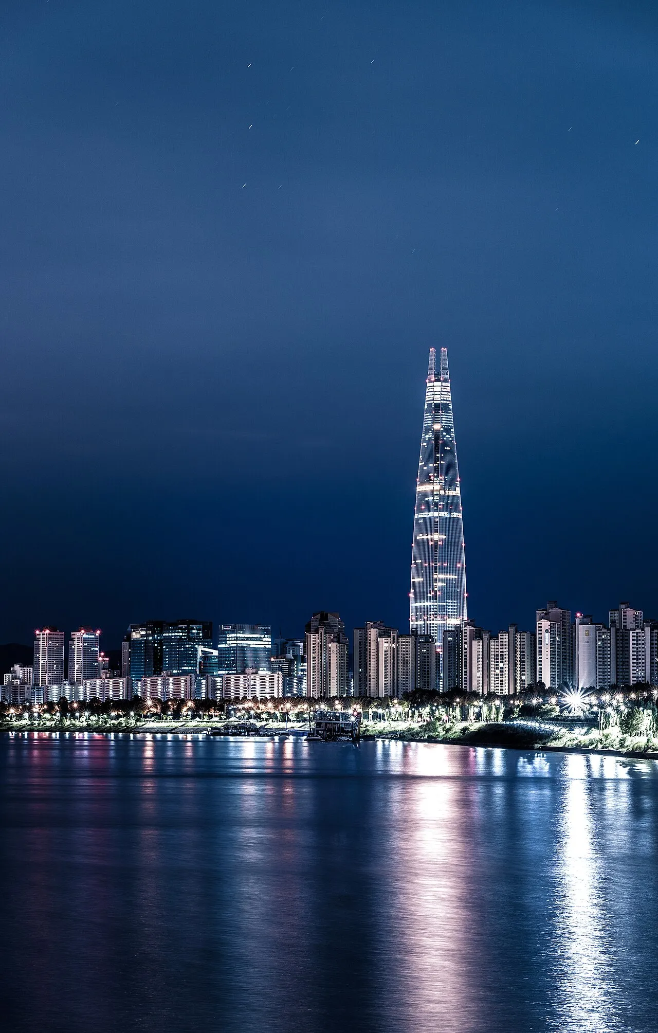 The Seoul skyline at night, a dense field of glowing towers along the Han River