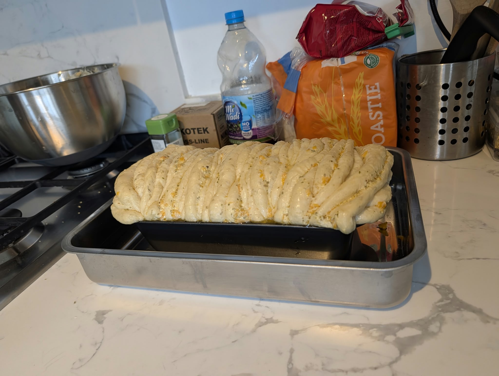 The same loaf after proving, now risen into a smooth dome standing well above the rim of the pan